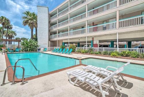 a swimming pool with lounge chairs in front of a building at Cozy one bedroom condo in Corpus Christi