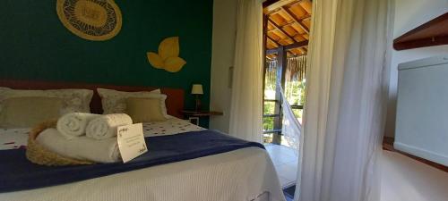 a bedroom with a bed with towels on it at Pousada Vila Mato Verde in Morro de São Paulo