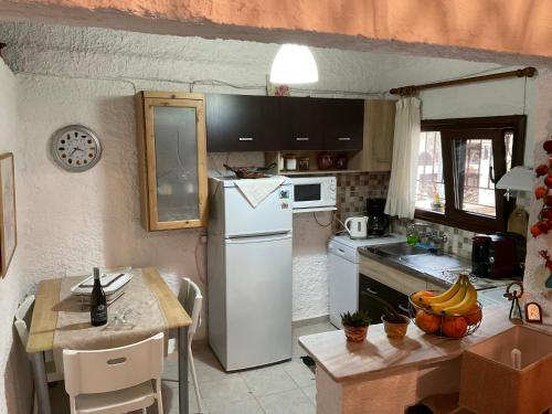 a kitchen with a white refrigerator and a table at Anni House in Stavros in Stavros