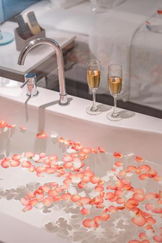 two glasses of wine sitting on a bathroom sink at Seaesta Nha Trang Hotel in Nha Trang