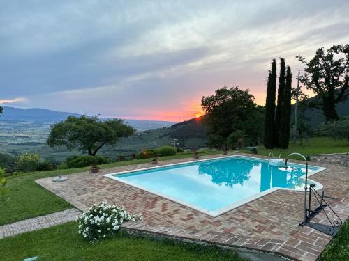 une piscine avec vue sur le coucher du soleil en arrière-plan dans l'établissement Le Logge Di Silvignano, à Campello sul Clitunno
