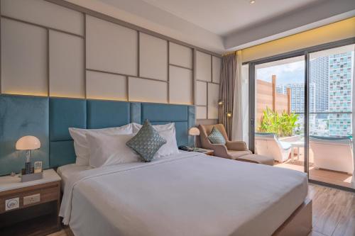 a bedroom with a large bed and a large window at Seaesta Nha Trang Hotel in Nha Trang
