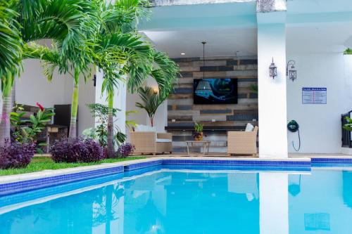 a swimming pool with a tv in a house at The Palm- A Luxury Villa in Retalhuleu