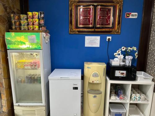 a blue wall with a refrigerator next to aiger at Ilhamku Inn in Kemaman