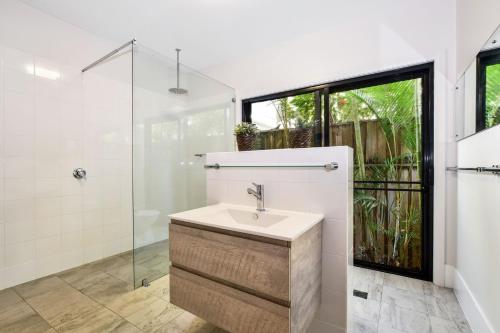 a bathroom with a sink and a glass shower at Bessou in Charlotte Bay