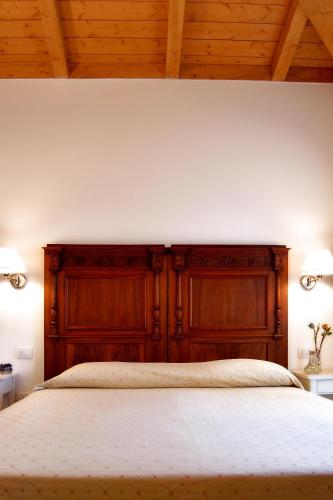 a bedroom with a large bed with a wooden headboard at Agriturismo Gaggioli Borgo Delle Vigne in Zola Predosa