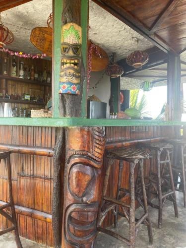 a wooden bar with a large totem pole at Un Dia Boutique Resort in Playas
