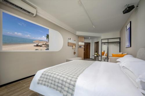 a bedroom with a bed and a view of the beach at Platinum Century Hotel in Huizhou