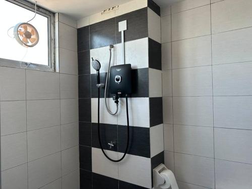 eine Dusche im Bad mit schwarzen und weißen Fliesen in der Unterkunft CEO7 Duplex Business Suite#Netflix#USM#Pisa#Pantai Hospital in Bayan Lepas