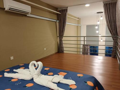 Un par de cisnes acostados en una cama en una habitación en CEO7 Duplex Business Suite#Netflix#USM#Pisa#Pantai Hospital, en Bayan Lepas