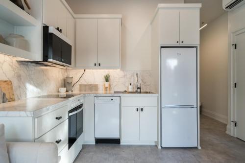 a kitchen with white cabinets and a refrigerator at The 505 Eugene in Eugene