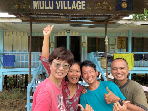 a group of three people posing for a picture at Mulu Village in Mulu