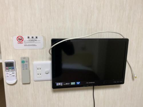 a tv with a remote control next to a remote control at 阪南国际HOTEL in Hannan