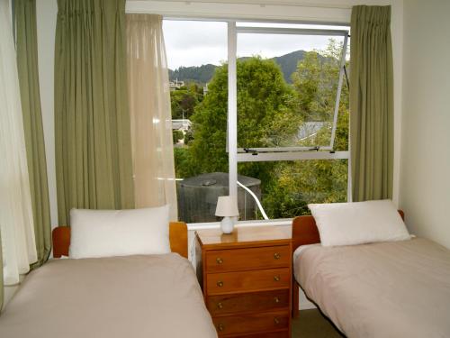 um quarto com 2 camas e uma janela com vista em Kea View - Pohara Beach Holiday Home em Pohara