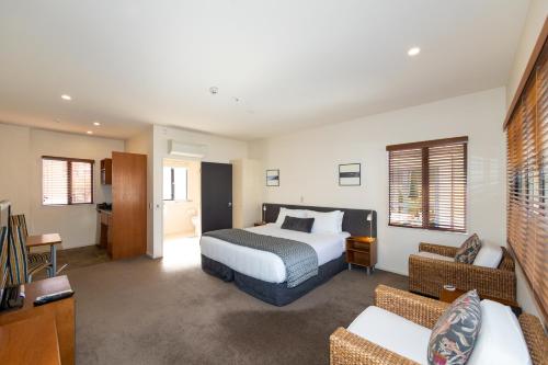 um quarto de hotel com uma cama e um sofá em Harvest Lodge Motel em Havelock North
