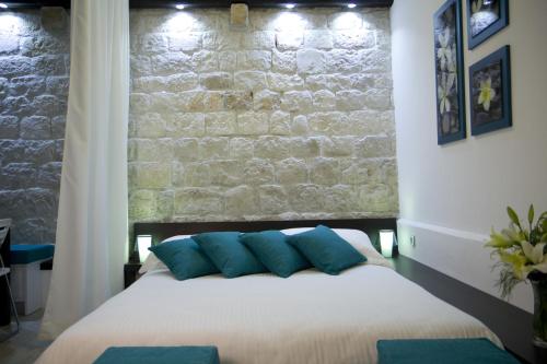a bedroom with a white bed with blue pillows at Studio apartment Malo more in Trogir