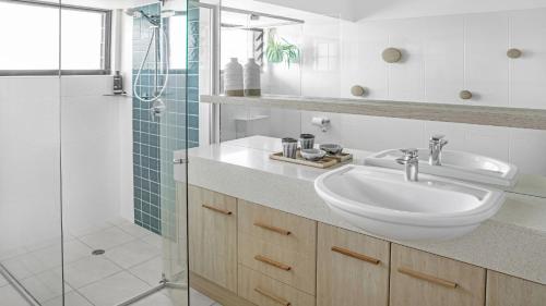 een witte badkamer met een wastafel en een douche bij Beachside Lennox 2 in Lennox Head