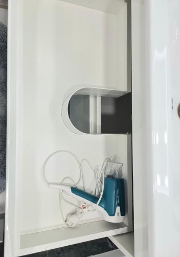 a white cabinet with a mirror and a blue item in it at Center, Albisoara str., 1bedroom and living with balcony in Chişinău