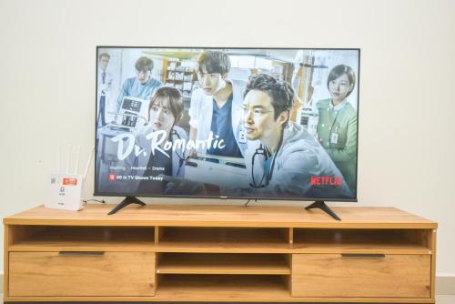 a flat screen tv sitting on top of a wooden stand at Meridin Medini Suite by Nest Home【LEGOLAND】 in Nusajaya