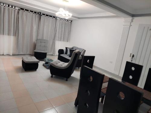 uma sala de estar com cadeiras pretas e um sofá em Encantador y Confortable Apartamento em Neiva