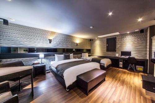 Jbis Hotel في Uijeongbu: غرفة فندق بها سريران ومكتب ومكتب