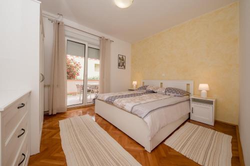a bedroom with a bed and a large window at Apartments Mar - 150 m from sea in Rab