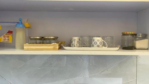a shelf with jars and other items on it at RASA - The Ganges Rishikesh, Ganga Bhumi Apartment in Rishīkesh