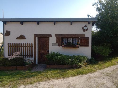 Cette petite maison blanche dispose d'une fenêtre et d'une porte. dans l'établissement La tiote roulotte, à Marquigny