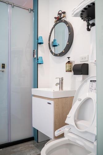 a bathroom with a toilet and a sink and a mirror at Milan Yilan in Wujie