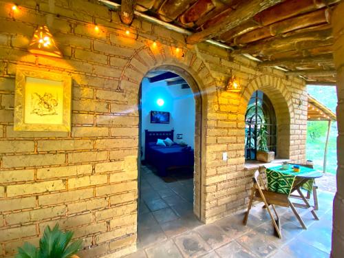 an archway in a brick wall with a table and a couch at Cabaña en Malinalco Zarla in Malinalco