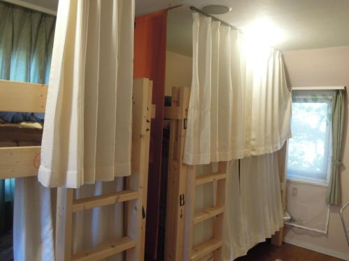 a room with two bunk beds and a window at Bellscabin Guesthouse in Karuizawa