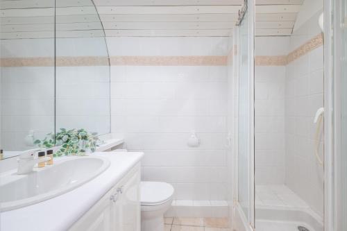 une salle de bain blanche avec des toilettes et un lavabo dans l'établissement Le Seize, cosy studio au coeur de la vieille ville de Menton, à Menton