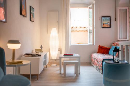 un petit salon avec un lit et une table dans l'établissement Le Seize, cosy studio au coeur de la vieille ville de Menton, à Menton