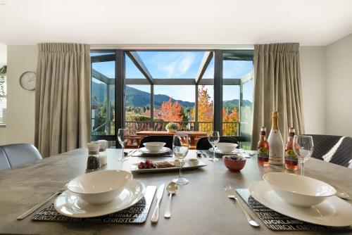 a dining room table with a view of the mountains at *** LAKE VILLA 467 *** in Hanmer Springs