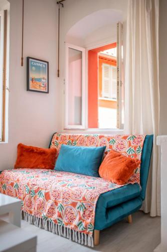 - un canapé avec des oreillers colorés dans le salon dans l'établissement Le Seize, cosy studio au coeur de la vieille ville de Menton, à Menton