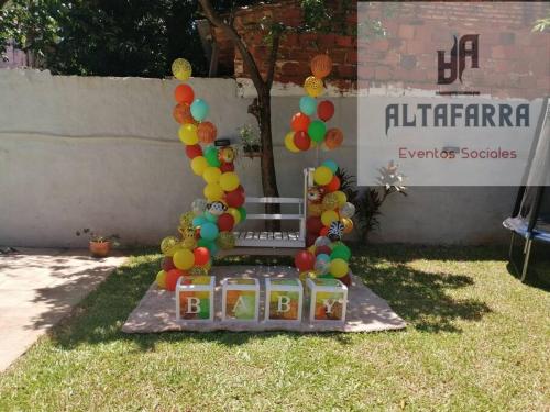 a party set up in the grass with balloons at casa con piscina, alojamiento hasta 12 personas in Asunción