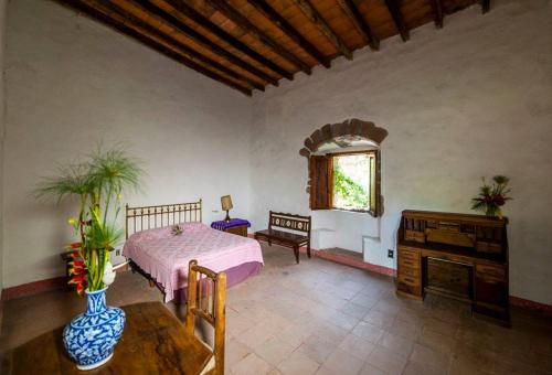 a bedroom with a bed and a table and a window at Hacienda la Luna in Tetecala
