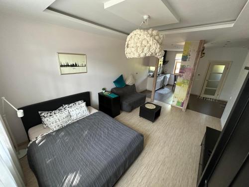 a bedroom with a bed and a living room at Studio apartment in private house in Rīga