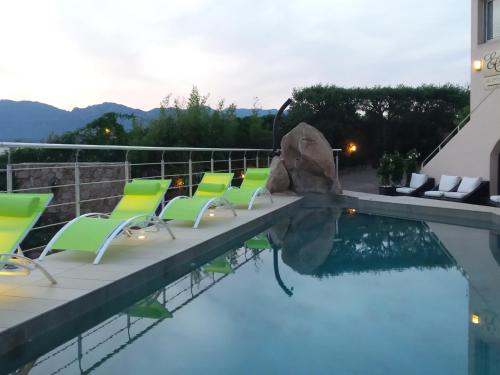 a pool with lounge chairs and a swimming pool at Private Hôtel - Adults Only in Porto-Vecchio