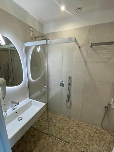 a bathroom with a glass shower and a sink at Hotel Golden in Rimini