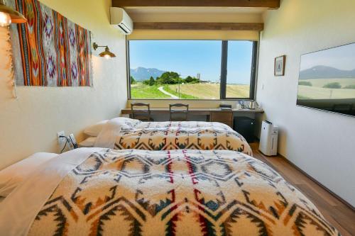 a bedroom with two beds and a large window at El Patio Ranch in Aso