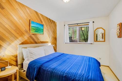 a bedroom with a blue bed and a window at Shangri Lodge Serene Retreat in Clinton