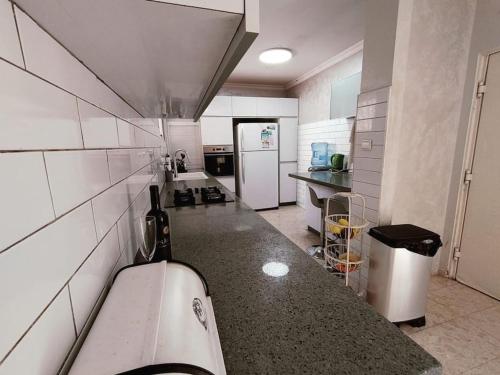eine Küche mit einer Theke und einem weißen Kühlschrank in der Unterkunft אחוזת דולב Dolev estate הווילה in Zanoaẖ