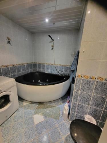 a bathroom with a bath tub and a toilet at Ranna Sadama Villa in Pärnu