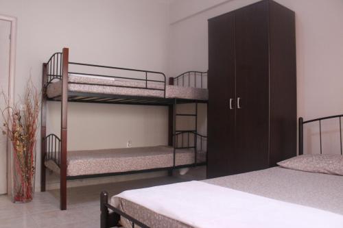 a bedroom with three bunk beds and a cabinet at Paralia Apartments in Paralia Katerinis
