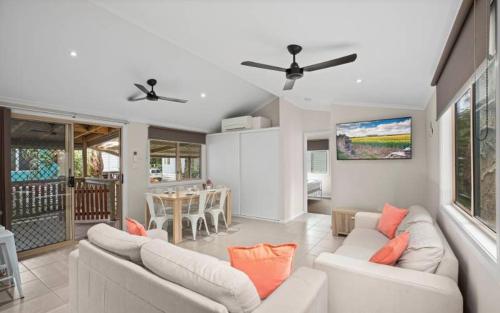 a living room with two white couches and a table at Sapphire Beach Holiday Park in Coffs Harbour