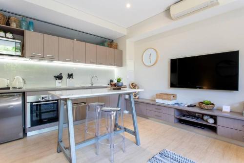 a kitchen with a counter and a tv on the wall at Dunn Bay Apartment 4 I Private Properties in Dunsborough