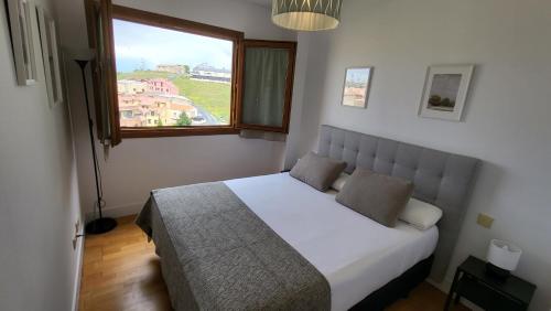 a bedroom with a bed with a large window at Las Casitas de Bernuy VUT in Segovia