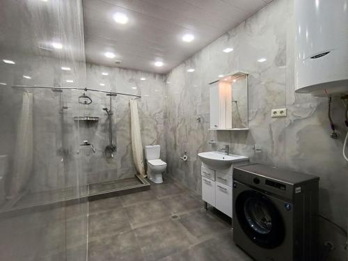 Apartment in centre of Yerevan في يريفان: حمام مع غسالة ومغسلة