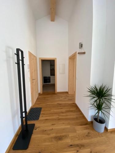 a hallway with white walls and a wooden floor at moderne Apartments am Attersee Dachsteinblick - ruhige Lage mit traumhaften Blick in Nussdorf am Attersee